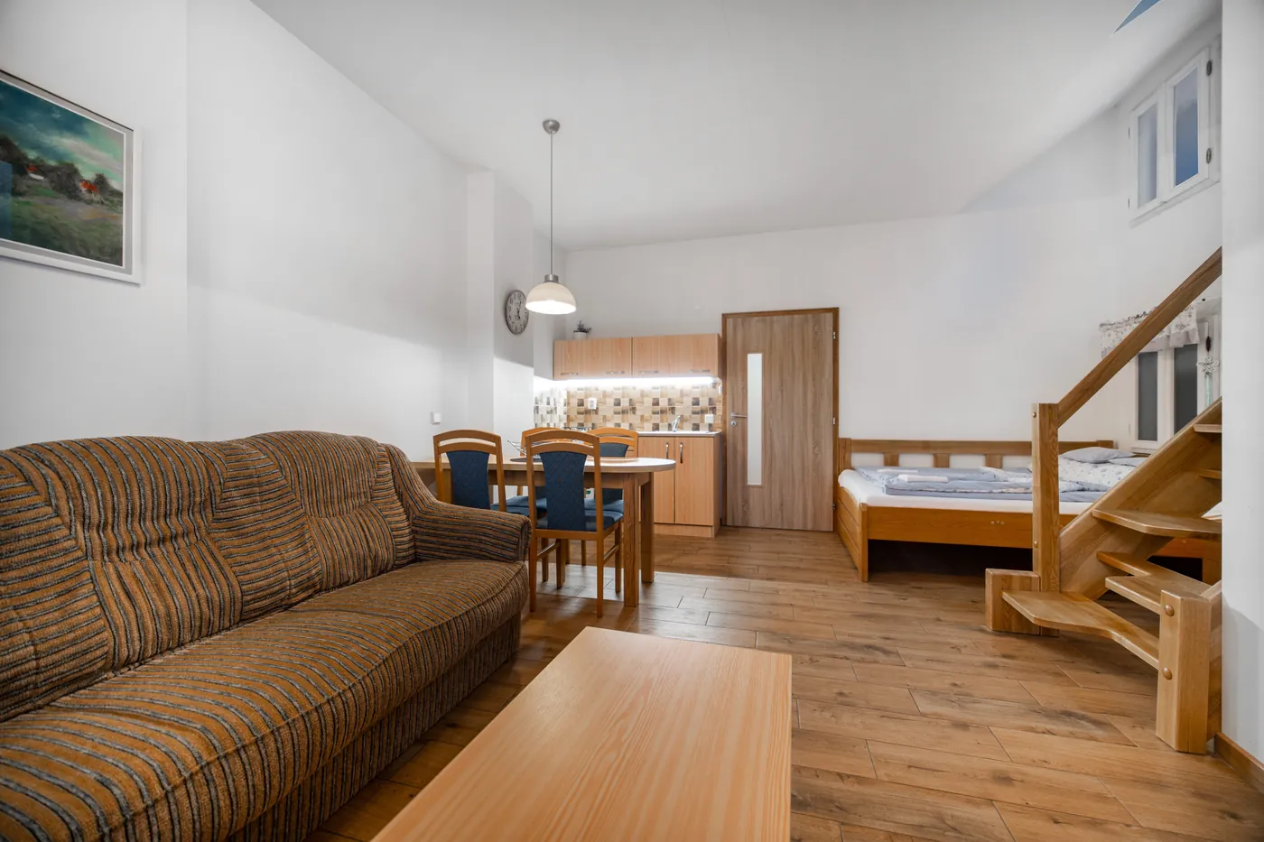 Apartmán s kuchyňským koutem a schodištěm do podkroví