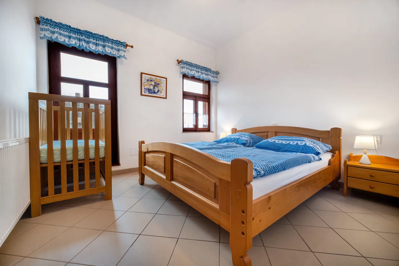 Pokoj s manželskou postelí a dětskou postýlkou