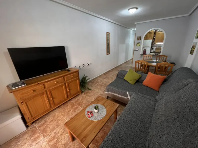 Obývací pokoj s rohovou sedačkou a televizí